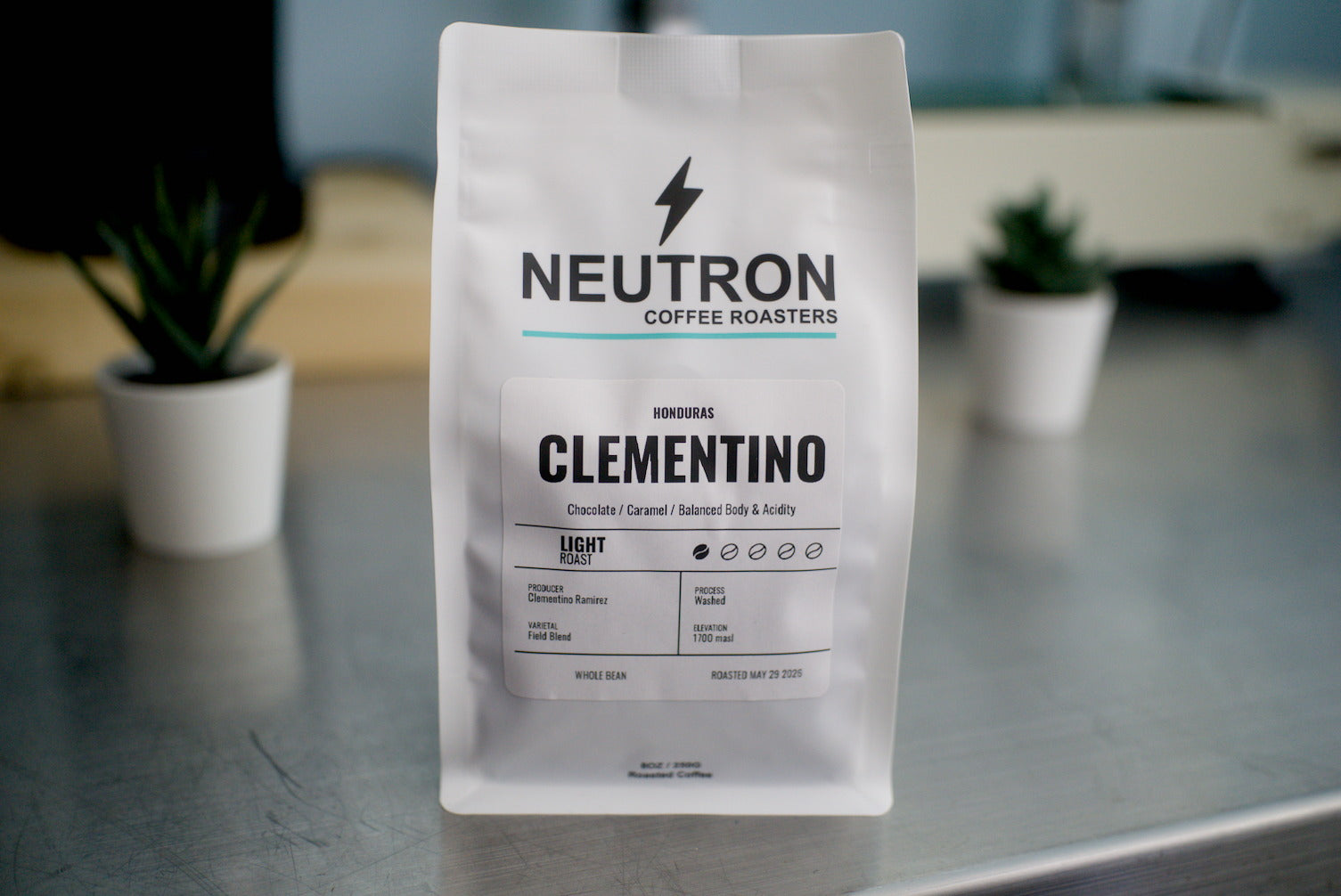 Neutron Coffee Roasters Clementino coffee bag on a metal surface with a blurred background.