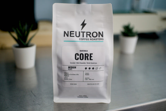 Neutron Coffee Roasters Core coffee bag on a metal surface with a blurred background.
